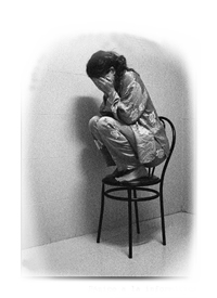 Fotografa en la que aparede una mujer, agachada sobre una silla, tapndose el rostro con las manos