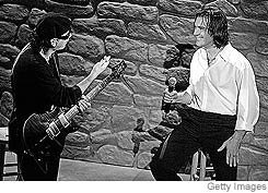 [Musician Carlos Santana (left) and actor Antonio Banderas perform 'Al Otro Lado del Rio' during the Academy Awards.]